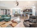 Open-concept living room with modern furnishings and adjacent kitchen and dining area, ideal for entertaining at 5144 Flowing Oar Rd, Wimauma, FL 33598