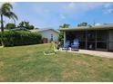 Lush backyard featuring a screened-in patio with comfortable seating and a well-manicured lawn at 119 Caddy Rd, Rotonda West, FL 33947