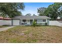 Charming single-story home with a blue exterior, well-maintained landscaping, and an attached garage at 2824 Oaklawn Ave, Largo, FL 33771