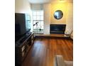 Cozy living room area with a white brick fireplace and wood flooring at 3628 Nettle Creek Ct, Holiday, FL 34691