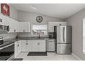Modern kitchen featuring white cabinets, granite countertops, stainless steel appliances, and marble floors at 4605 Steel Dust Ln, Lutz, FL 33559