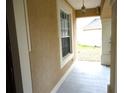 Covered front porch with decorative columns, exterior lighting, and textured stucco walls at 11511 Misty Isle Ln, Riverview, FL 33579