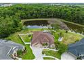 Aerial view showcasing the home, landscaping, pond, pool, and cul-de-sac street at 27740 Water Ash Dr, Wesley Chapel, FL 33544