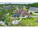 Aerial view of a backyard with screened-in pool, fire pit, and lush green space at 27740 Water Ash Dr, Wesley Chapel, FL 33544