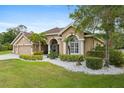 Beautiful single-story home featuring meticulous landscaping with flowering bushes at 27740 Water Ash Dr, Wesley Chapel, FL 33544