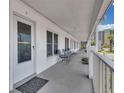 Exterior walkway featuring a seating area, a door, and views of the surrounding complex and landscaping at 680 71St Ave # 9, St Pete Beach, FL 33706