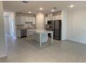 Open-concept kitchen features stainless steel appliances and a granite countertop island at 32122 Eastern Redbud Br, San Antonio, FL 33576