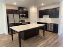 Modern kitchen with stainless steel appliances, a center island, and dark wood cabinetry at 32128 Eastern Redbud Br, San Antonio, FL 33576