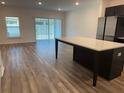 Open-concept kitchen and living area with wood-look floors and natural light at 32128 Eastern Redbud Br, San Antonio, FL 33576