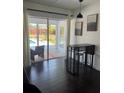 Dining area with patio view to the pool, dark wood floors, and modern decor at 821 Silver Springs Nw Ter, Port Charlotte, FL 33948