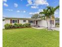 Well-maintained home with vibrant landscaping, a lush green lawn, and a charming front facade at 5710 92Nd N Ter, Pinellas Park, FL 33782