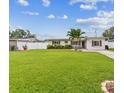 Inviting single-story home featuring a lush green lawn, vibrant plants, and a welcoming front entrance at 5710 92Nd N Ter, Pinellas Park, FL 33782