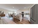 Open-concept kitchen and dining area featuring modern appliances and a kitchen island at 14673 Italy Ave, Dade City, FL 33523