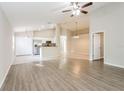 Open-concept living room with tile and wood-look flooring and access to the kitchen at 24237 Rolling View Ct, Lutz, FL 33559