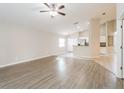 Open-concept living room showcasing wood-look floors, neutral walls and seamless access to kitchen at 24237 Rolling View Ct, Lutz, FL 33559