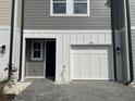 Close-up of the exterior of townhome featuring a one-car garage and neutral-toned siding at 7677 Deer Valley Circle, Tampa, FL 33635