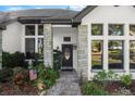Inviting front entrance with stone accents and manicured garden bed featuring lush plants at 36846 Perry Ct, Dade City, FL 33525