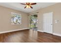 Bright living room with hardwood floors, fan, and sliding glass doors to a patio at 6412 Coquina Island Cv, Apollo Beach, FL 33572
