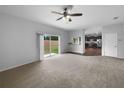Spacious living room with a sliding glass door that leads to the backyard and an open view of the kitchen at 10768 Carloway Hills Dr, Wimauma, FL 33598