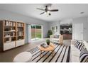 Bright living room boasts sliding glass doors, ceiling fan, and stylish black and white accents at 10768 Carloway Hills Dr, Wimauma, FL 33598