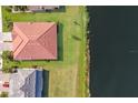 An aerial view of a house with a tile roof next to a pond at 2532 Avolet Ct, Lakewood Ranch, FL 34211