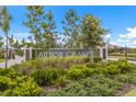 View of the community sign surrounded by lush plants at 2532 Avolet Ct, Lakewood Ranch, FL 34211