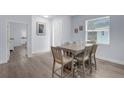 A light-filled dining area with modern wood table, chairs, and wood flooring at 146 51St Street E Cir, Palmetto, FL 34221