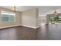 Open-concept living area with wood-look flooring, neutral walls, and sliding doors to the lanai at 530 Bimini Bay Blvd, Apollo Beach, FL 33572