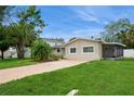 Charming single-story home boasts a spacious front yard, mature trees, and an enclosed porch at 4651 Helena Ne St, St Petersburg, FL 33703