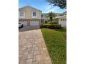 Charming townhome with a paver driveway, lush landscaping, and an attached one car garage at 915 Woodbridge Ct, Safety Harbor, FL 34695