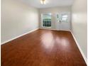 Bright, empty living room featuring gleaming hardwood floors, a ceiling fan and white trim at 915 Woodbridge Ct, Safety Harbor, FL 34695