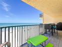 Balcony overlooking white sand beach and ocean with outdoor seating and dark metal railing at 14146 Gulf Blvd # 3A, Madeira Beach, FL 33708