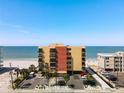 Beachfront condo building with balconies, parking, and palm trees, offering stunning ocean views and easy beach access at 14146 Gulf Blvd # 3A, Madeira Beach, FL 33708
