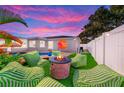 Inviting backyard featuring a modern outdoor fire pit, plush seating, and unique wall mural for relaxation at 9497 122Nd Way, Seminole, FL 33772