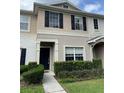 Inviting townhome exterior featuring tidy landscaping, neutral paint and a covered front porch at 5864 Fishhawk Ridge Dr, Lithia, FL 33547