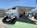 View of the carport of a mobile home featuring a golf cart, seating and parking at 10315 Cortez W Rd # 18D, Bradenton, FL 34210