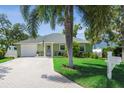 Charming single-story home featuring a well-manicured lawn, mature trees and inviting front entrance at 3404 W Villa Rosa St, Tampa, FL 33611