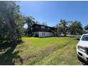 Two-story home featuring lush lawn and a backdrop of mature shade trees at 359 S Orchid Dr, Ellenton, FL 34222