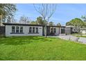 Charming single-story home with a well-maintained lawn, updated landscaping, and a light blue front door at 3926 Helena Ne St, St Petersburg, FL 33703