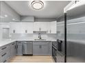 Modern kitchen featuring stainless steel appliances, white subway tile backsplash, and gray and white cabinets at 3926 Helena Ne St, St Petersburg, FL 33703