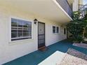 Entryway to a condo unit with a well-maintained walkway and tidy landscaping at 1415 Doolittle Ln # 106, Dunedin, FL 34698