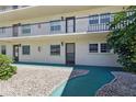 Close up of the entrances to the condo units with manicured landscaping and walkways at 1415 Doolittle Ln # 106, Dunedin, FL 34698