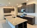 Modern kitchen features dark cabinetry, granite countertops, stainless steel appliances, and a spacious island at 27206 Adams St, Punta Gorda, FL 33983