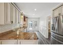 Bright kitchen with granite countertops, stainless steel appliances, and white cabinets at 6503 N Wellington Ave, Tampa, FL 33604