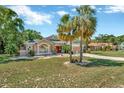 Inviting single-Gathering home boasting lush landscaping, mature palm trees, and a well-maintained lawn at 14680 Linden Dr, Spring Hill, FL 34609