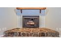 Close-up of a unique fireplace with a stone base and wooden mantel at 2006 Sycamore Ln, Plant City, FL 33563