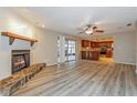 Open-concept living area showcasing hardwood floors, a cozy fireplace, and a view of the kitchen at 2006 Sycamore Ln, Plant City, FL 33563