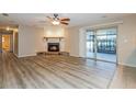 Spacious living room featuring wood floors, a fireplace with a stone base, and sliding glass doors at 2006 Sycamore Ln, Plant City, FL 33563
