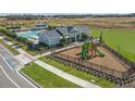 Aerial view of community playground and pool with a lounge area and other neighborhood amenities at 28875 Seedling St, Wesley Chapel, FL 33543
