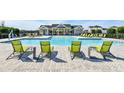 Inviting community pool featuring lounge chairs for relaxing and enjoying the sun at 28875 Seedling St, Wesley Chapel, FL 33543